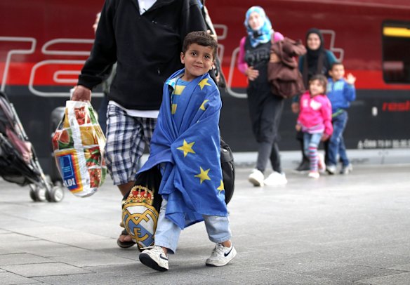 A migrant boy wrapped in an EU flag arrives from Austria at Munich Hauptbahnhof main railway station in Munich, Germany. 