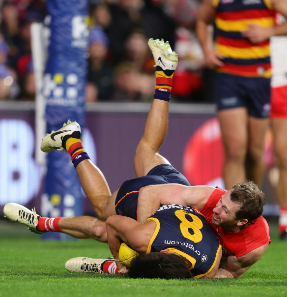 Josh Rachele of the Crows is tackled by Harry Cunningham.