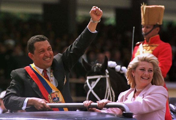 In this Feb. 4, 1999 file photo, Venezuela's newly sworn in President Hugo Chavez salutes the crowd next to his wife Marisabel Chavez during a military parade commemorating the seventh anniversary of his failed 1992 coup in Caracas, Venezuela.