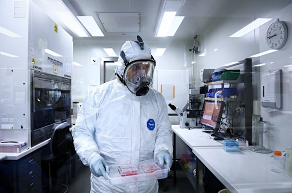 Associate Professor Stuart Turville a virologist at the Kirby Institute working temporarily at St Vincent's Centre for Applied Medical Research, carrying a COVID-19 Omicron variant sample to analyse the antibody reaction.