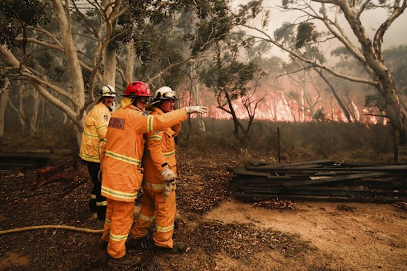 RFS firefighters working to protect properties as the North Black Range bushfire threatens properties at Bombay, NSW.