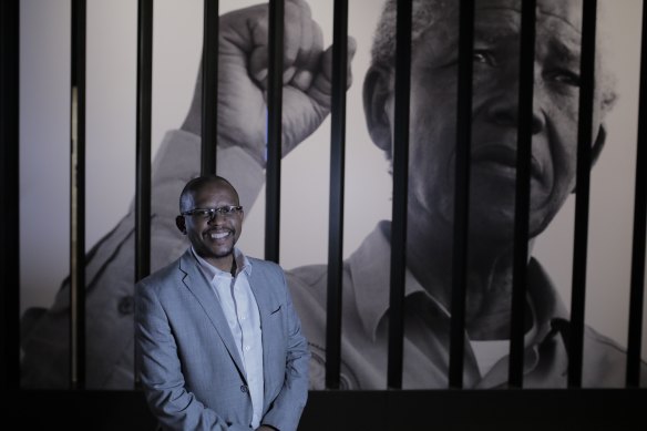 Sello Hatang, CEO of The Nelson Mandela Foundation, with Mandela in the background