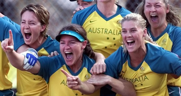 Australian players Sandra Allen, left, Melanie Roach, in visor, Natalie Ward, and Joanne Brown, back right, wait for Peta Edebone to come to home plate after hitting the game-winning two run homer in the bottom of the 13th inning against the USA women's softball team. 