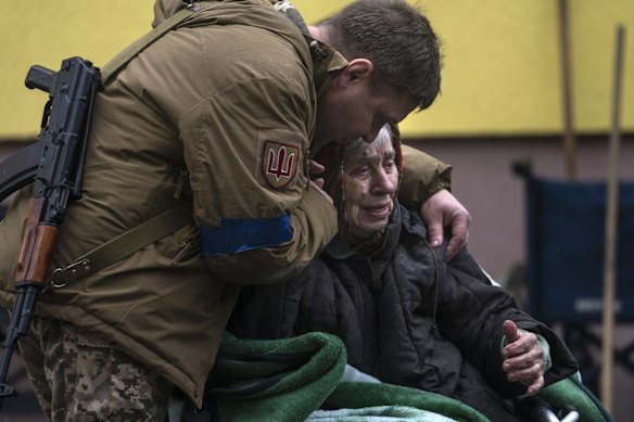 A soldier comforts Larysa Kolesnyk, 82, after being evacuated from Irpin, on the outskirts of Kyiv.