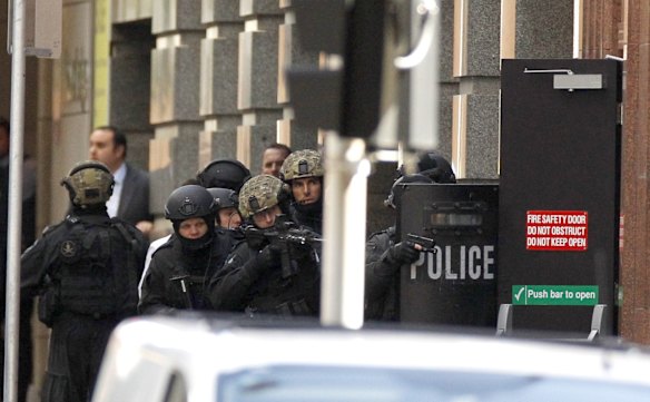 Heavily armoured Police keep weapons trained on the entrance to the Lindt Chocolate Cafe in Martin Place.