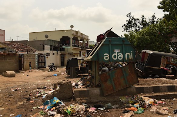 An Adani rubbish bin lies broken and overflowing on the streets of Mundra, home to Adani's main port and power plant, which has been accused of gross violations of environmental safeguards.