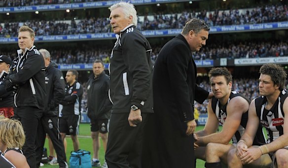 Collingwood coach Mick Malthouse centre, assistant coach Nathan Buckley , left and president Eddie McGuire right watch the presentation to Geelong aftr losing the Grand Final in 2011.