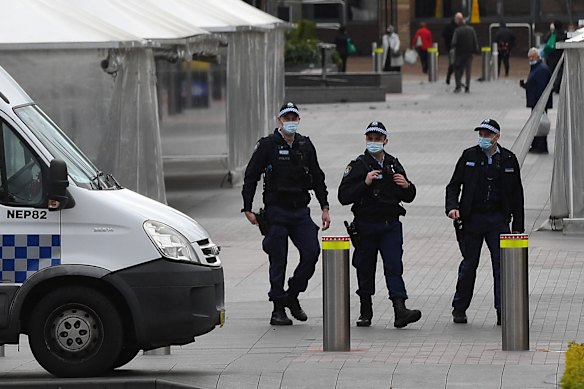 NSW Police patrol alongside a NSW Police mobile command unit parked at the Liverpool mall, as COVID restrictions tighten across Sydney.