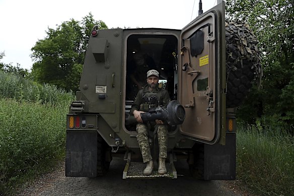 Ukrainian soldier and driver Vitaly holds an NLAW (Next generation Light Anti-tank Weapon) as he sits at the rear of the Bushmaster.
