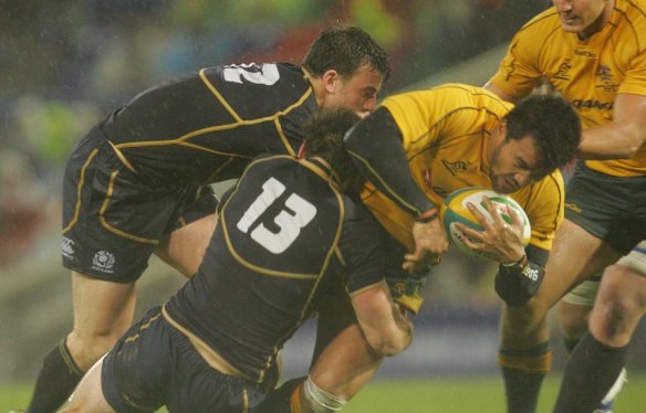 Australia's Digby Loane is tackled by Scotland's Matthew Scott (L) and Nick De Luca.