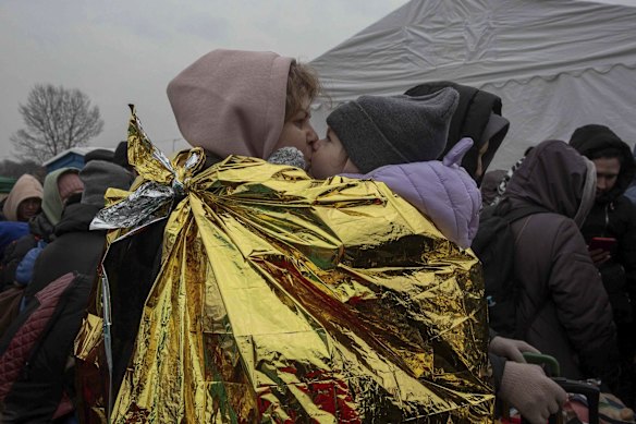 A woman kisses a child after fleeing from the Ukraine and arriving at the border crossing in Medyka, Poland. Russia announced yet another ceasefire and a handful of humanitarian corridors to allow civilians to flee Ukraine. Previous such measures have fallen apart and Moscow's armed forces continued to pummel some Ukrainian cities with rockets on Monday.