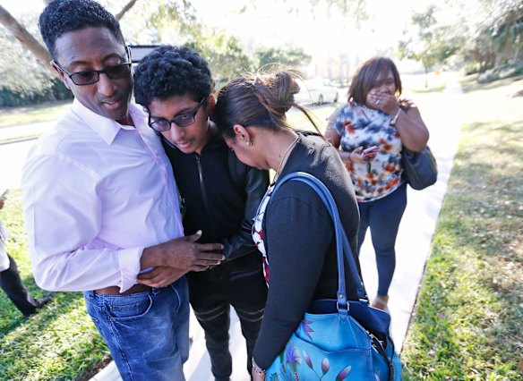 Family members embrace after a student walked out from Marjory Stoneman Douglas High School, Wednesday, Feb. 14, 2018, in Parkland, Fla.