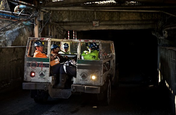 Springvale mine workers share a joke as their personnel train starts the long descent underground.