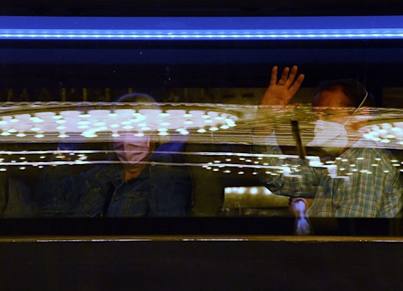 Groups of overseas travellers who have been in quarantine since arriving back in Sydney are transported out of the Swissotel.