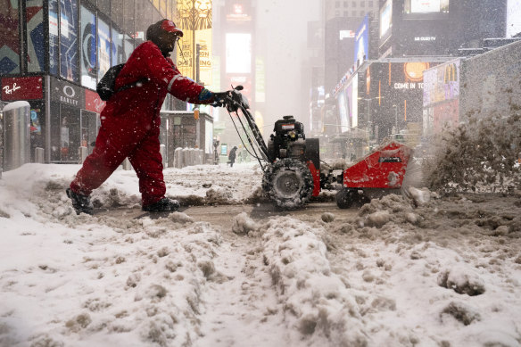 A Times Square Alliance worker clears the snow. 