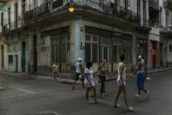 Residents cross a street near the Gran Teatro de La Habana Alicia Alonso, where President Barack Obama is scheduled to speak during his official visit to Cuba.