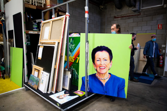 Head packer Brett Cuthbertson inspects Adam Norton’s portrait of Sydney Lord Mayor Clover Moore.