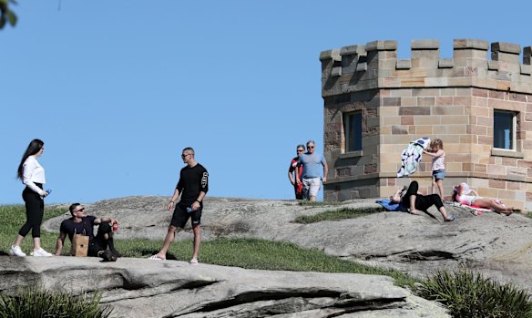 People sunbathe at La Perouse, Sydney. April 5, 2020