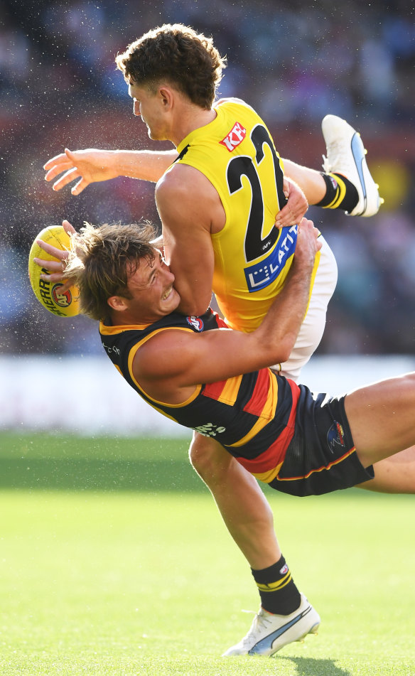 Jacob Hopper of the Tigers tackled by  Luke Pedlar of the Crows.