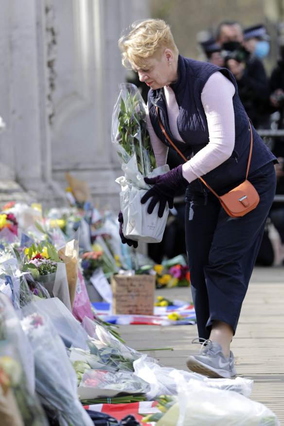 A member of the public leaves a floral tribute.