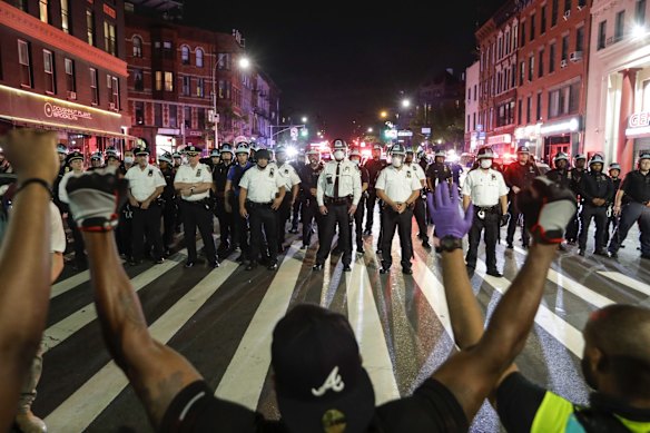 Protesters take a knee on Flatbush Avenue in front of New York City police officers during a solidarity rally for George Floyd, in the Brooklyn borough of New York.