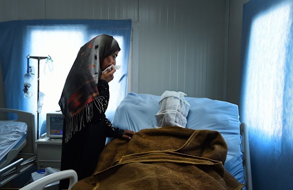 Sana Abdul Amir tends to her son Abdulrahman Abdulaaly, 18, who is being treated for 60% burns to his body at the ICU in Athba Field Hospital. 