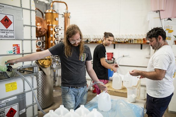 Bar Manager Sean McGuire, Production Manager Geordie Donaldson and Co-Owner Jesse Kennedy bottle hand sanitizer at Poor Toms Distillery. The company has started to produce hand sanitizer alongside their normal gin production after being approached by Doctors who had run out due to the outbreak of Coronavirus.