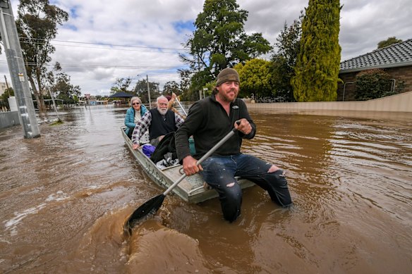Tom Collins and mate Tim Tyler rescuing Max and Julia Hastilow from their home,  taking them to a dry home.