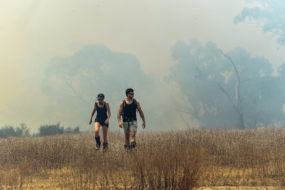 Bush walkers leaving the park with fire close behind.