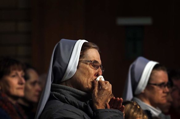 A nun and member of the Australian Ukrainian community wipes her nose during a prayer vigil for those killed in the crash of Malaysia Airlines flight MH17, at the St Andrew's Ukrainian Catholic church in Sydney July 19, 2014. Australian Prime Minister Tony Abbott blamed Russia on Friday for the shooting down of MH17 over eastern Ukraine, killing all 298 people on board, including 28 Australians. Abbott appeared to go further than other Western leaders in apportioning blame over the crash, demanding that Moscow answer questions about the "Russian-backed rebels" that he said were behind the disaster.
