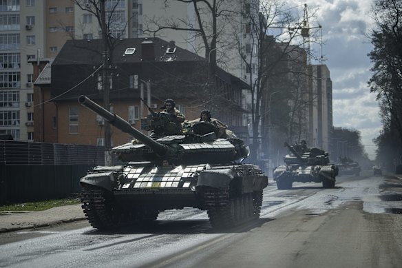 Ukrainian tanks move down a street in Irpin.