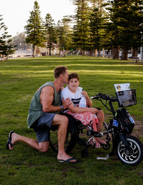 Jamie Crichton with his son Curtis Crichton at Manly beach. They spent Curtis' 13th birthday spraying hands of the public with sanitizer to kill germs and to spread good vibes. 