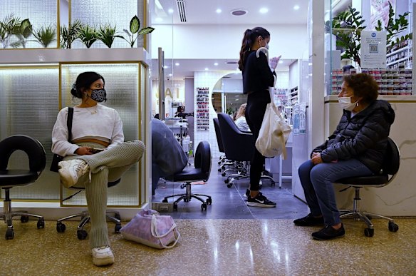Pauline Pinete, left, waits to enter a nail salon in Westfield Bondi Junction shopping centre on the first day of relaxed COVID-19 restrictions for fully vaccinated people.