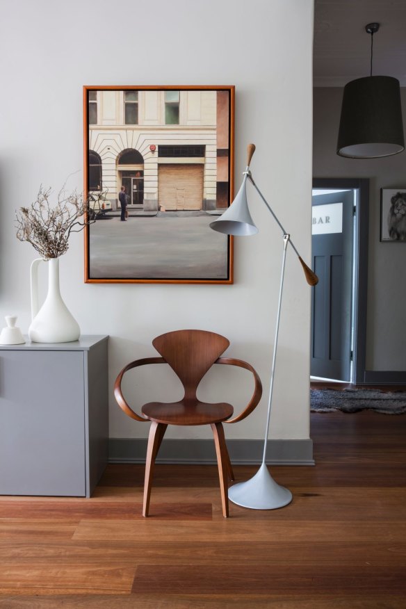 A corner of the home’s main living room. The artwork is by Christopher McVinish and the chair by Norman Cherner. In the background, Claire has fitted a vintage bar door on the bathroom. 