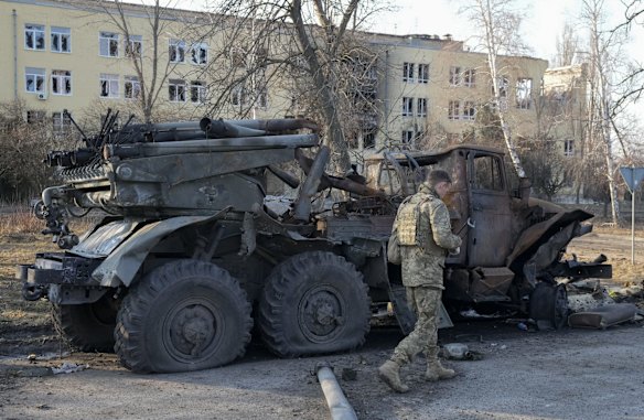 A Ukrainian soldier passes by a destroyed Russian artillery system 'Grad', in Kharkiv.