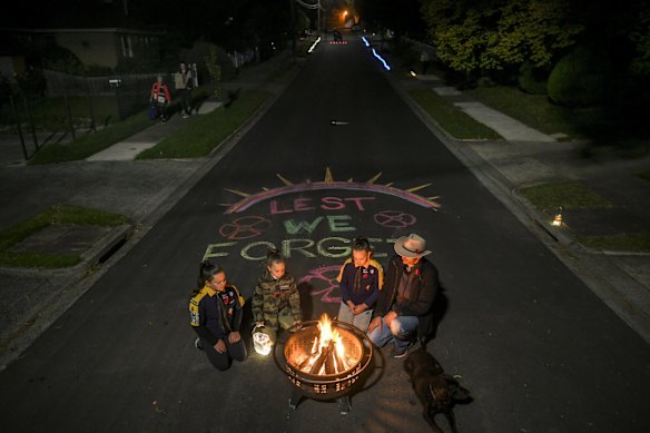 Mark di Pasquale and his daughters, Jessica, 10, Elouise, 9, Alexis, 7, hold their own Anzac Day service  in the Melbourne suburb of Macleod on April 25, 2020.
