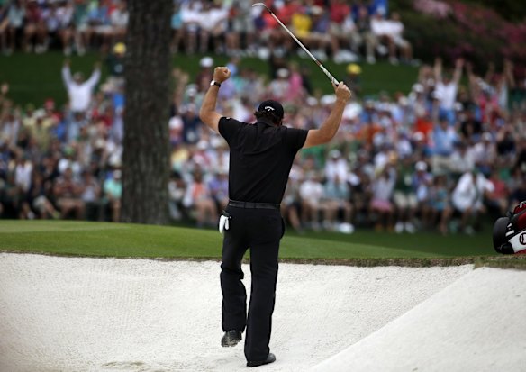 Phil Mickelson celebrates after hitting out of a bunker on the 15th.