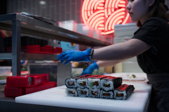 Sushi Hub staff preparing teriyaki beef rolls for the lunch rush.