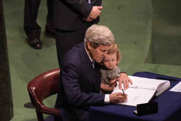 John Kerry signing the Paris Accords to reduce global greenhouse emissions to tackle climate change in 2016 with his granddaughter.  As President Biden's special climate envoy, Kerry is expected to lead America's diplomatic efforts to accelerate climate action globally. 