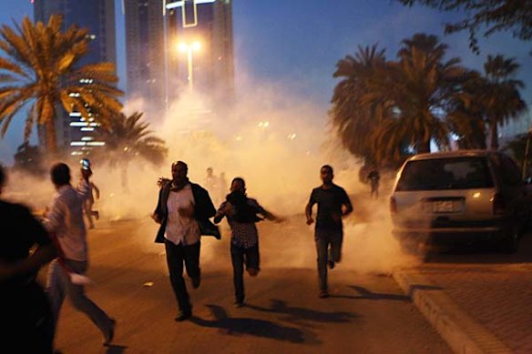 Protesters run from a cloud of teargas during a clash with Bahraini security forces.