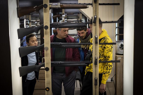 Customers inspect weapons in a gun shop in Lviv. 