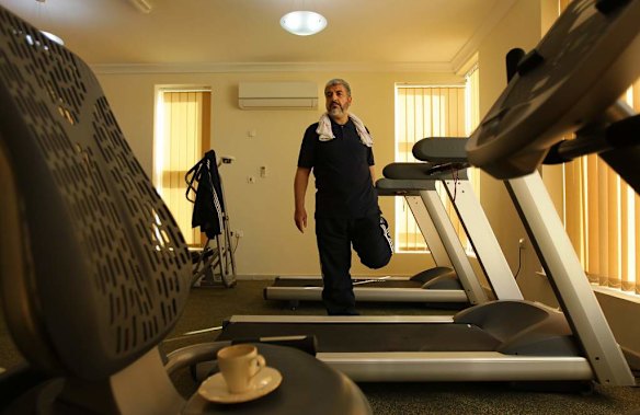 Khalid Mishal stretches after a work out in a friends private gym in Doha, Qatar.