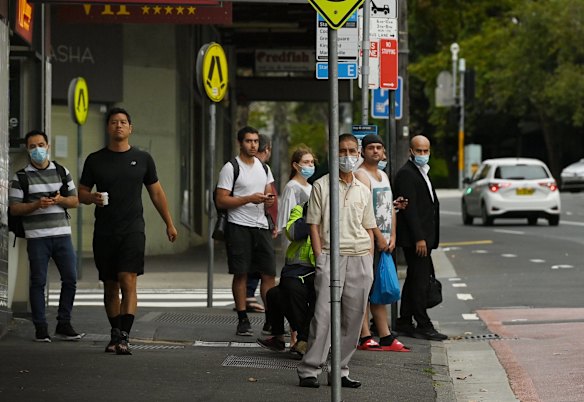 People wait for buses near Central Station after all Sydney Trains and Trainlink services were stopped due to industrial action.