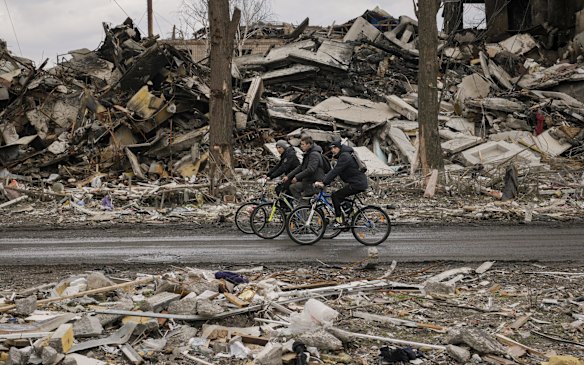 Men ride bicycles through destroyed apartment buildings in the town of Borodyanka outside Kyiv. Ukraine is preparing for what could be a major push by Moscow's forces to seize the country's industrial east.