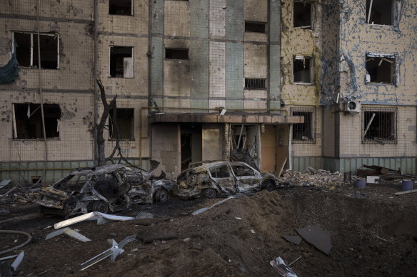 A crater is seen in front of a heavily damaged residential building after bombing in Kyiv, Ukraine, on Sunday.