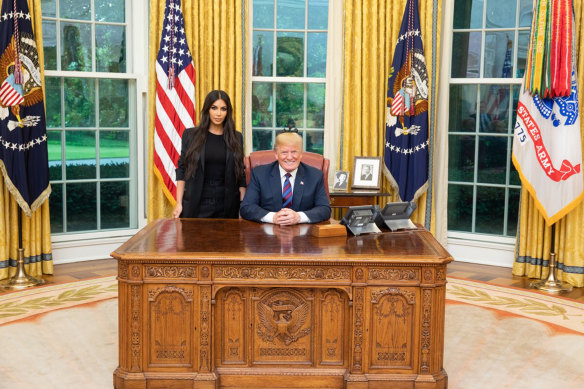 President Donald Trump poses with Kim Kardashian at the Oval Office at The White House in May.