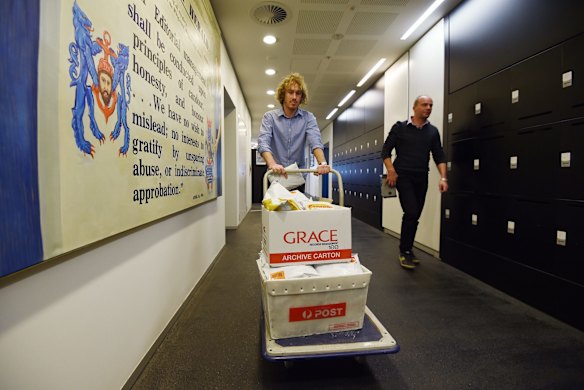 Charlie Falkner (left) from The Sydney Morning Herald newsroom takes the MH17 seed packages down to the Fairfax Media mailroom/loading dock in Sydney for the despatching of the packages to the families and friends of the 38 Australians who died when Malaysian flight MH17 was shot down.