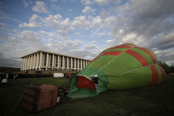Hot air balloons inflating on the lawns in front of Old Parliament House for the Canberra Balloon Spectacular festival.