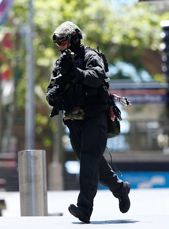 A police officer moves closer to the scene of the siege in Martin Place.