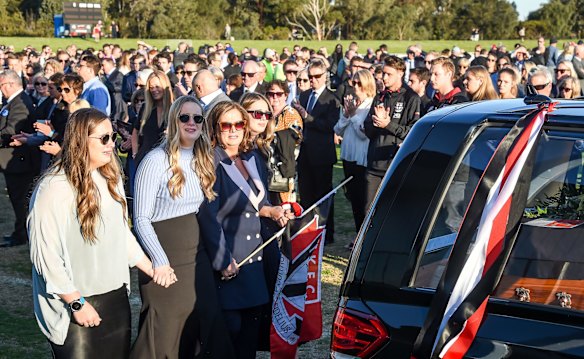  Danny Frawley's hearse does a lap of honour of Morabbin Oval with wife Anita and three daughters walking behind.